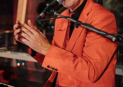 Christian Fürst Sänger, Keyboard-Spieler, Musiker, Bandleader Voices And Music, begeistere Zuhörer, roter Anzug, Mikrofon